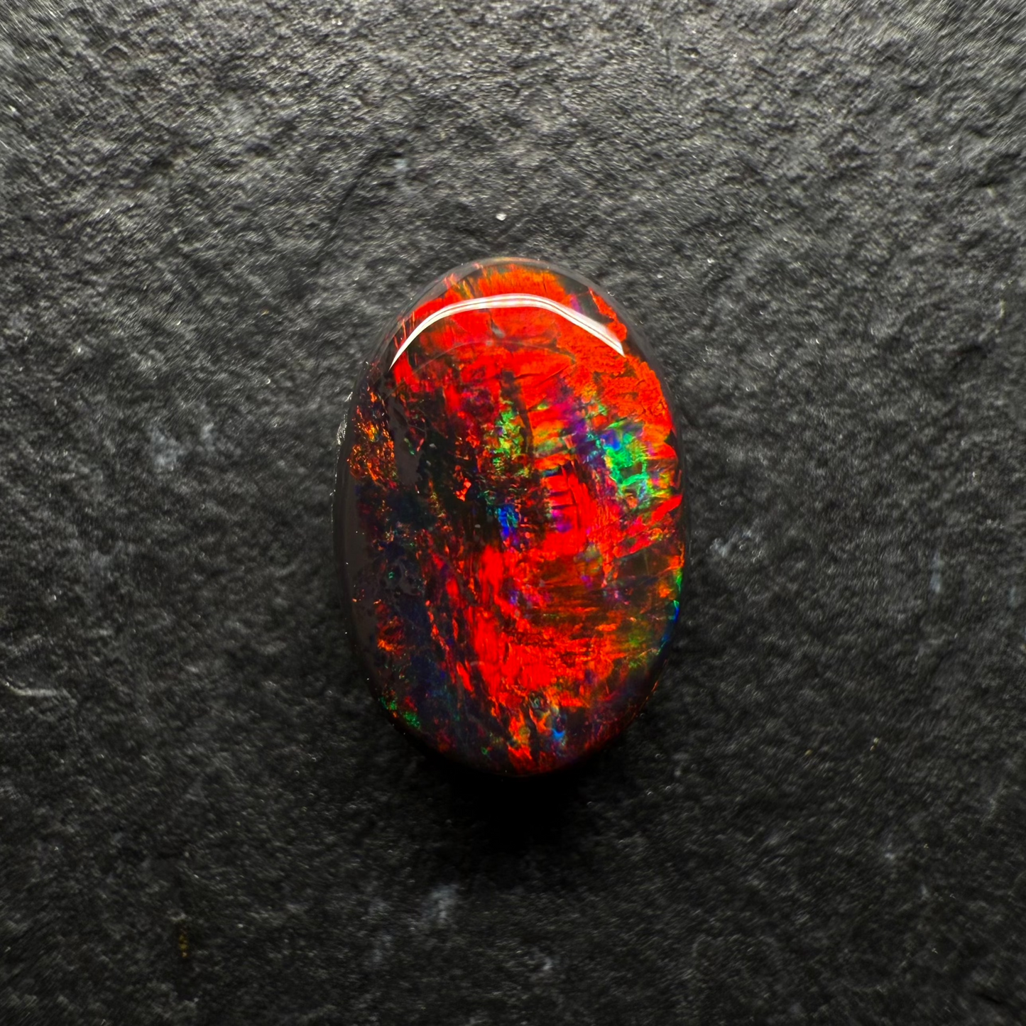 0.7ct World Class Black opal, This stone has a Primarily Pigeons Blood Red Color Palette (The Rarest Color Found In Opal)