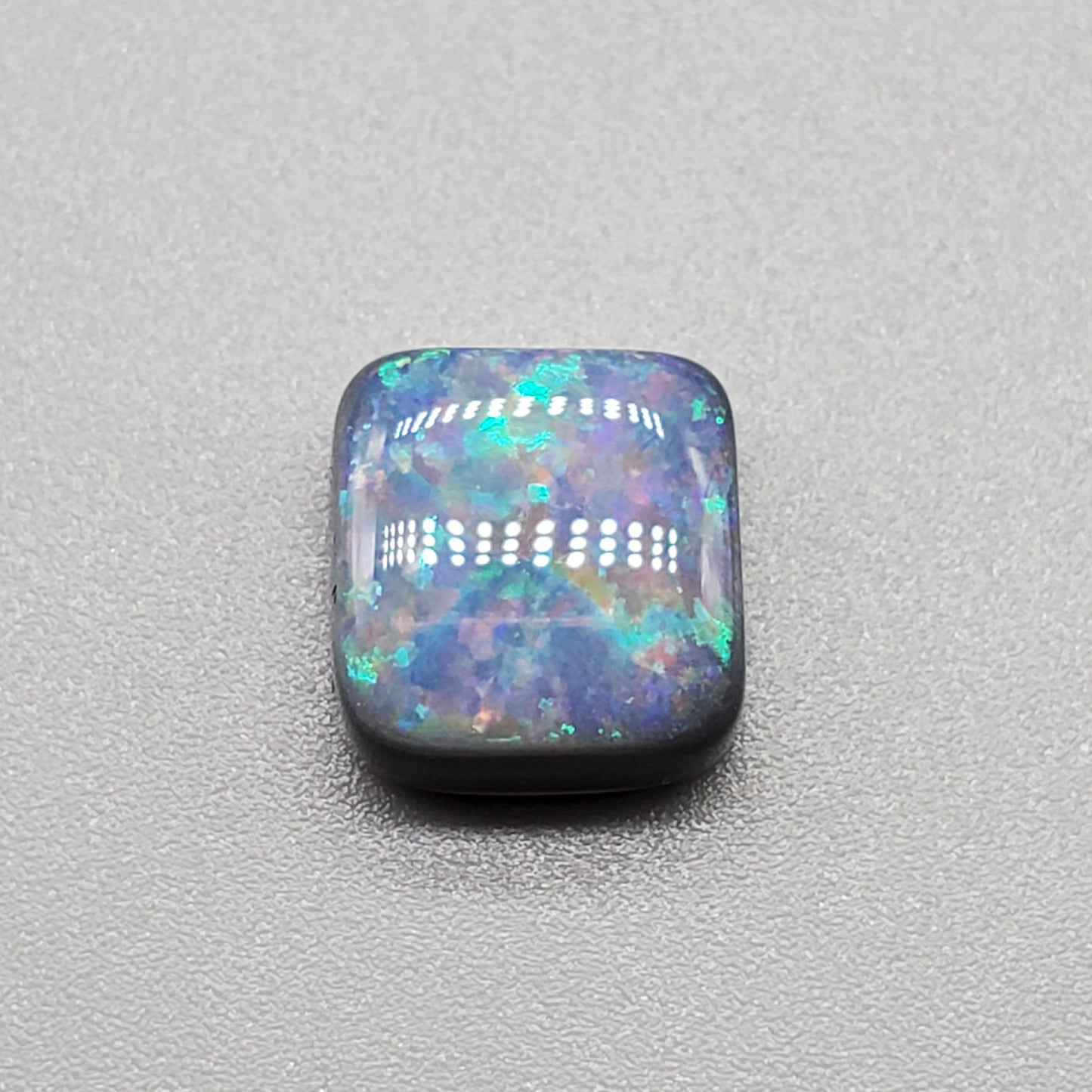 3.7cts Cushion cut black opal with a well-dispersed pattern of subtle pastel colors