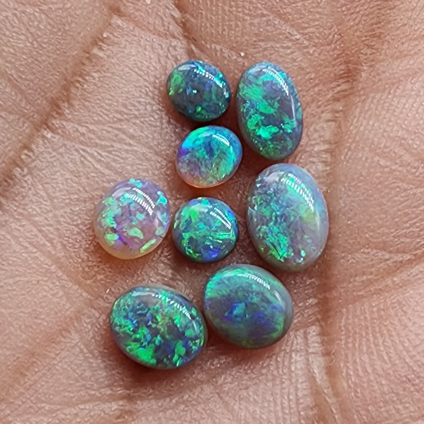 Assorted crystal and Dark Opals with bright blue green color and high quality patterns and color dispersal