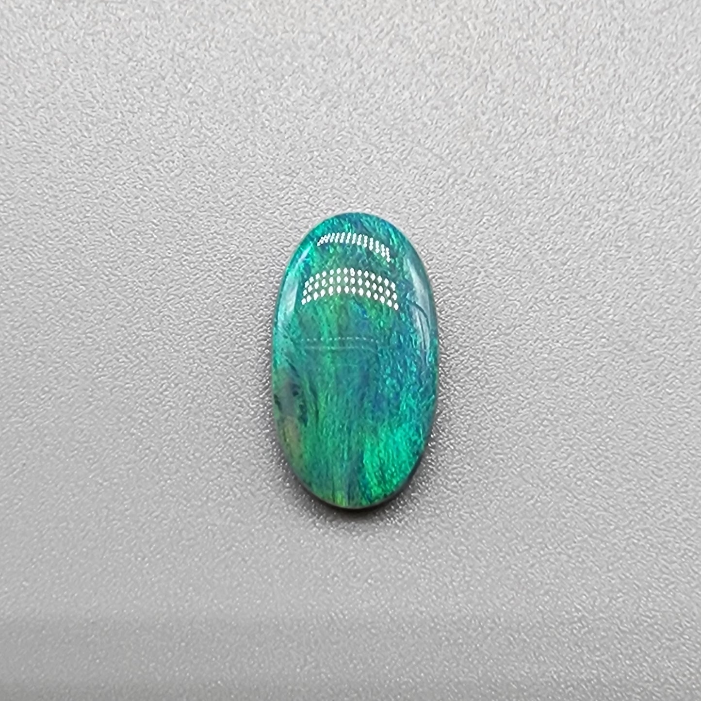 3.0ct teal colored black opal with a striated moss pattern