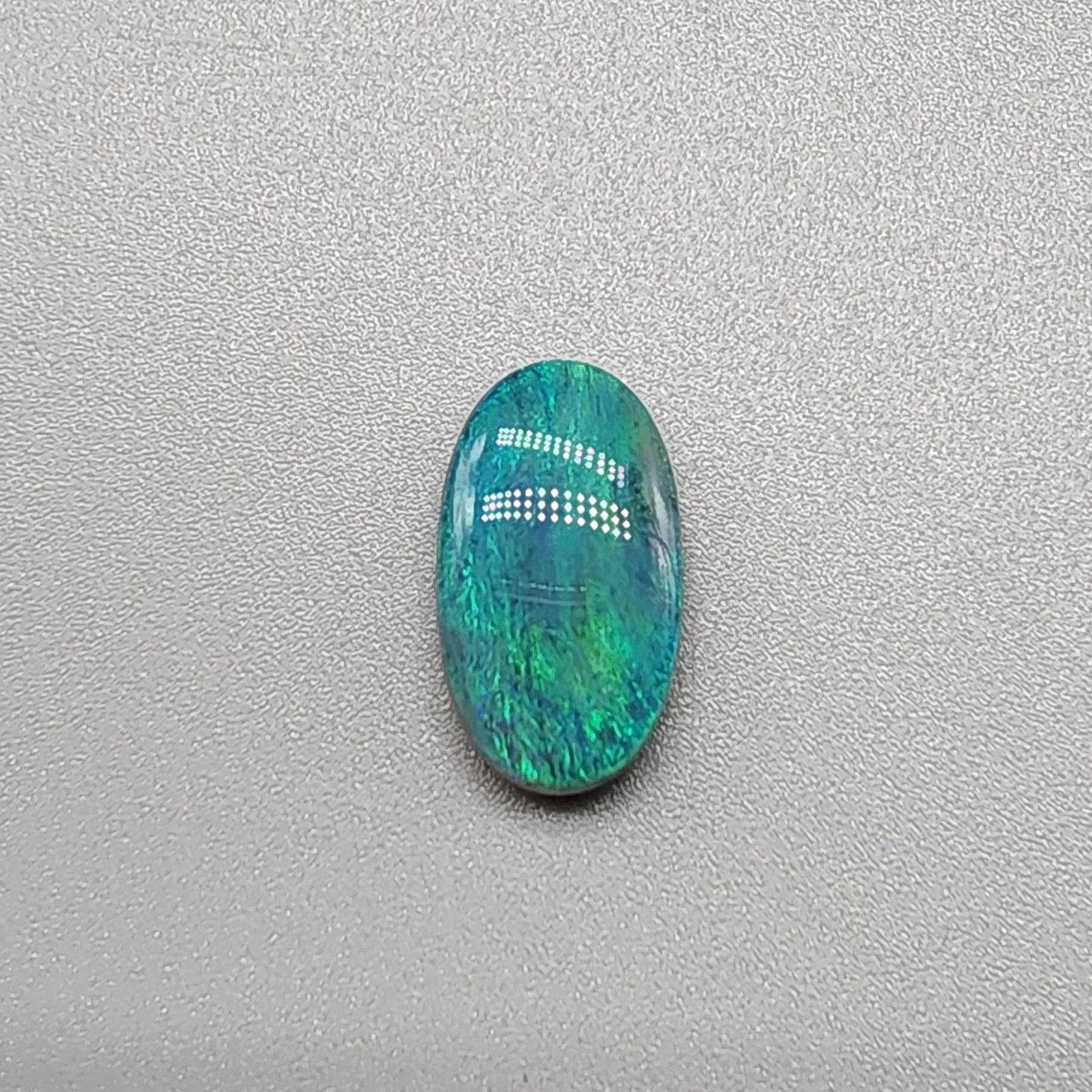 3.0ct teal colored black opal with a striated moss pattern