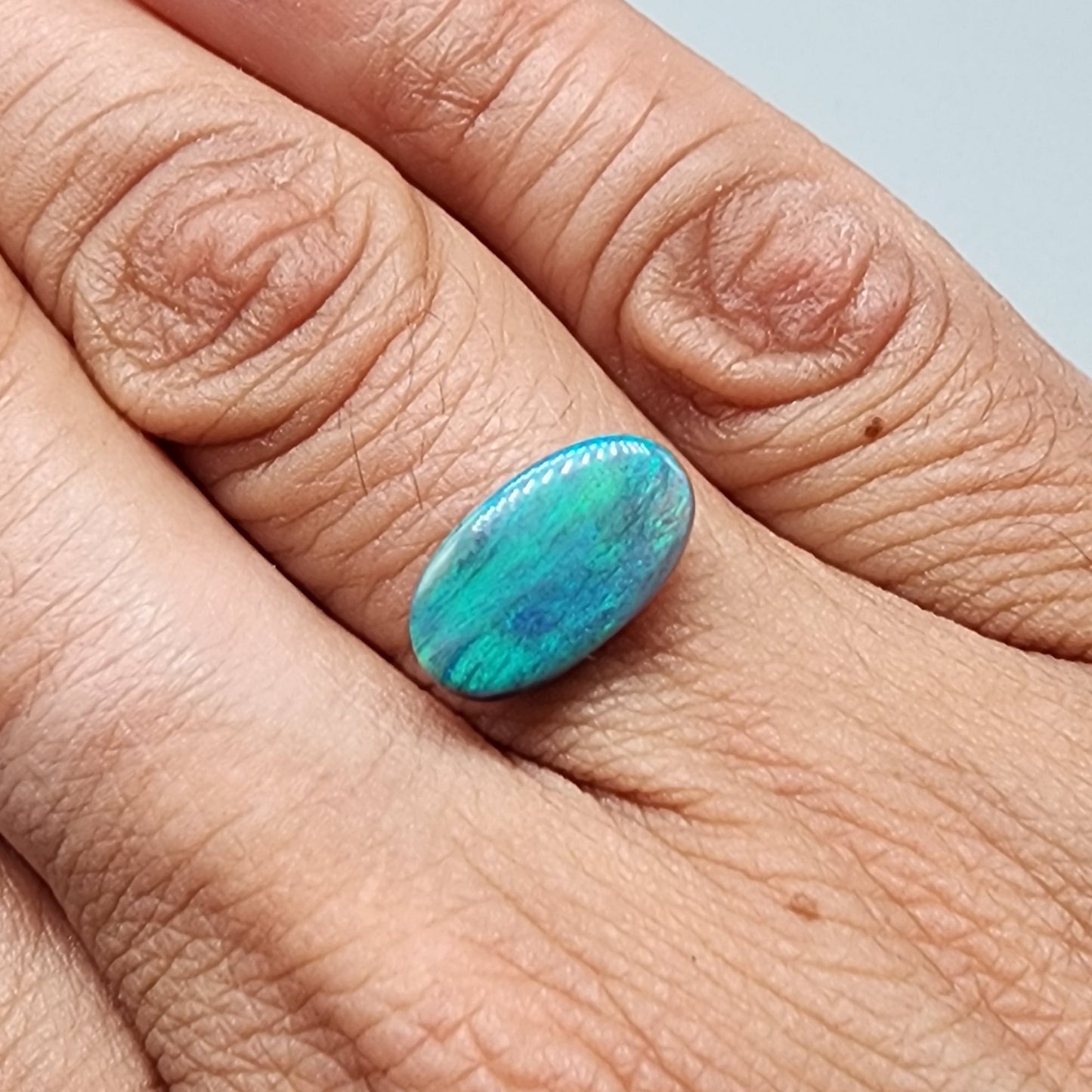 3.0ct teal colored black opal with a striated moss pattern