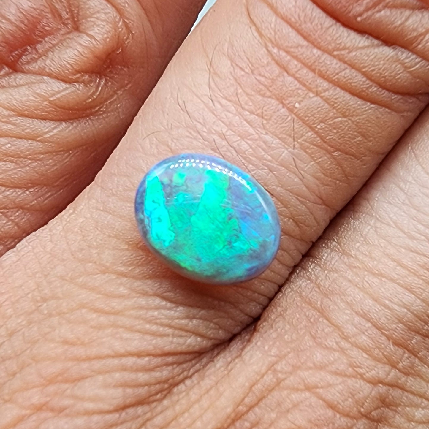 1.6cts Dark Opal with a teal color pallet and a blocky broad flash pattern.