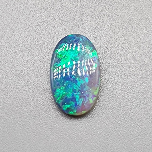 1.35ct Half black opal, half crystal opal with vivid green flash.