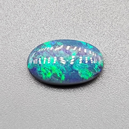 1.35ct Half black opal, half crystal opal with vivid green flash.