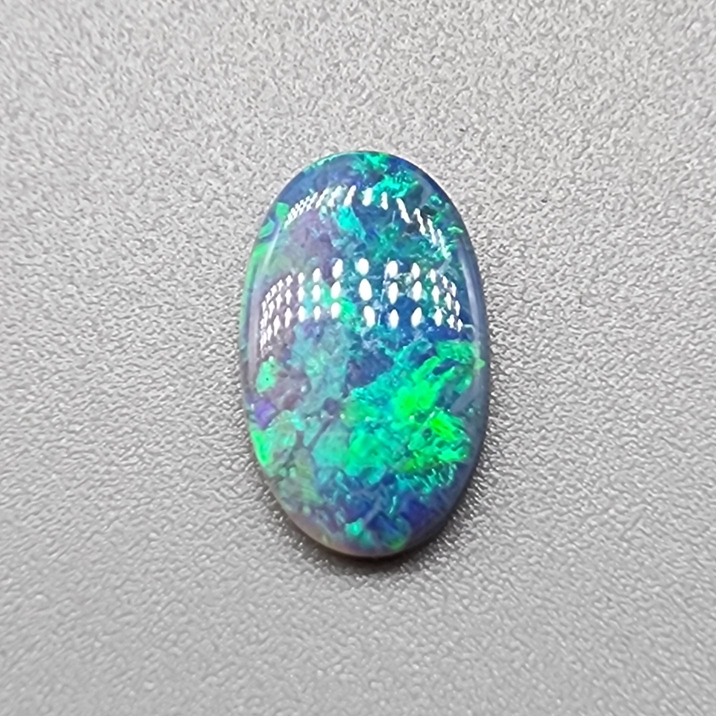 1.35ct Half black opal, half crystal opal with vivid green flash.