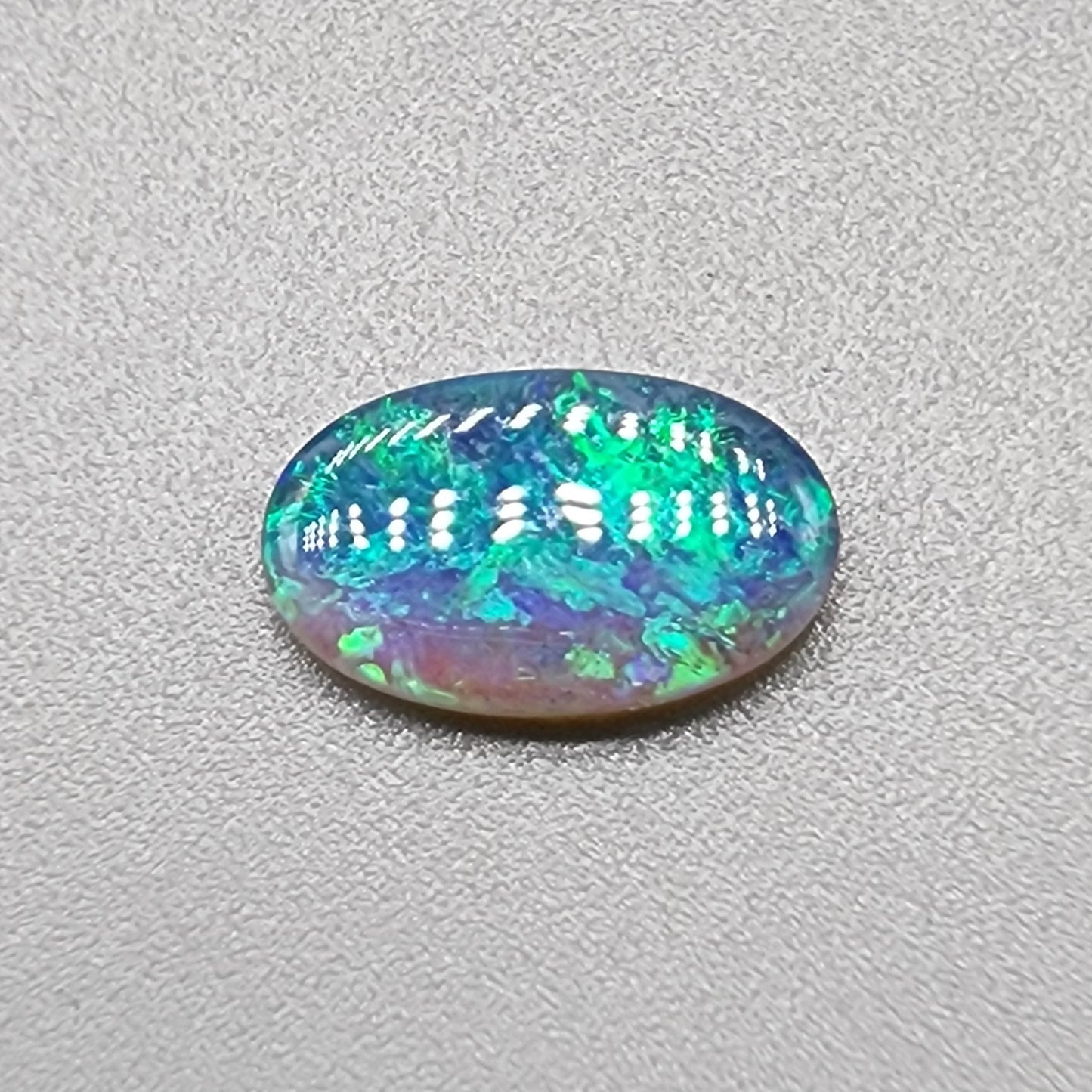 1.35ct Half black opal, half crystal opal with vivid green flash.