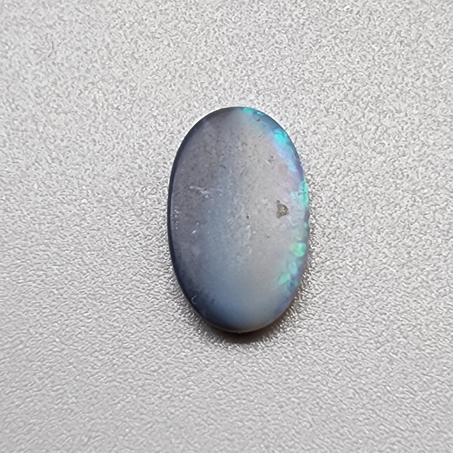 1.35ct Half black opal, half crystal opal with vivid green flash.