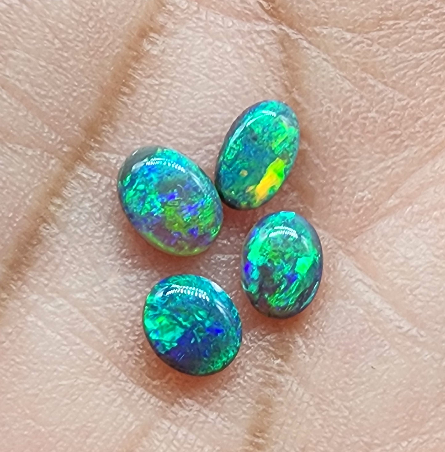 Assorted black opals with vivid greens, golds and blues