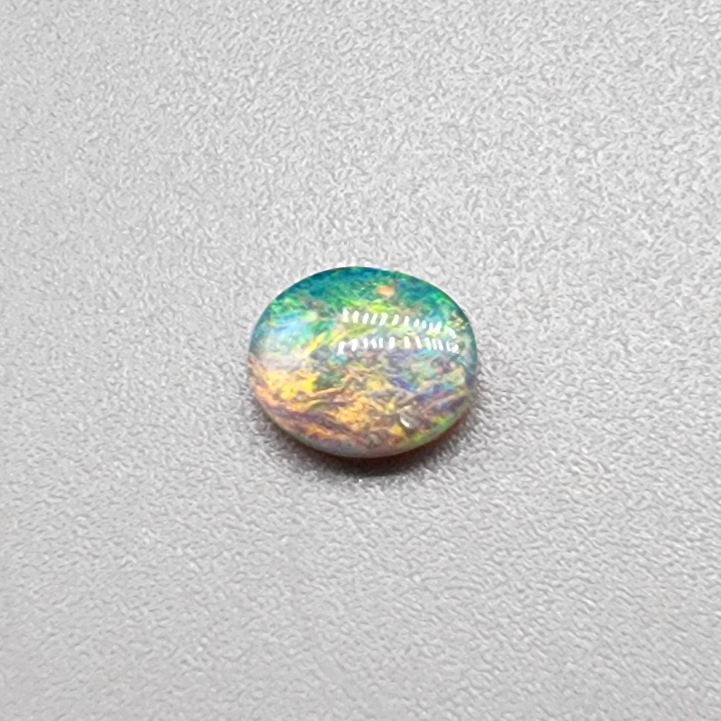 0.55ct Dark Opal with a multicolor striated pattern