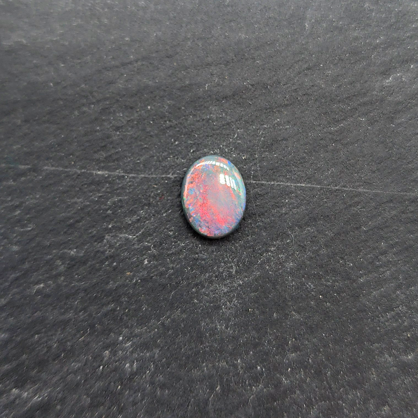 Black opal with bright pink small fire pattern and hints of blue and green