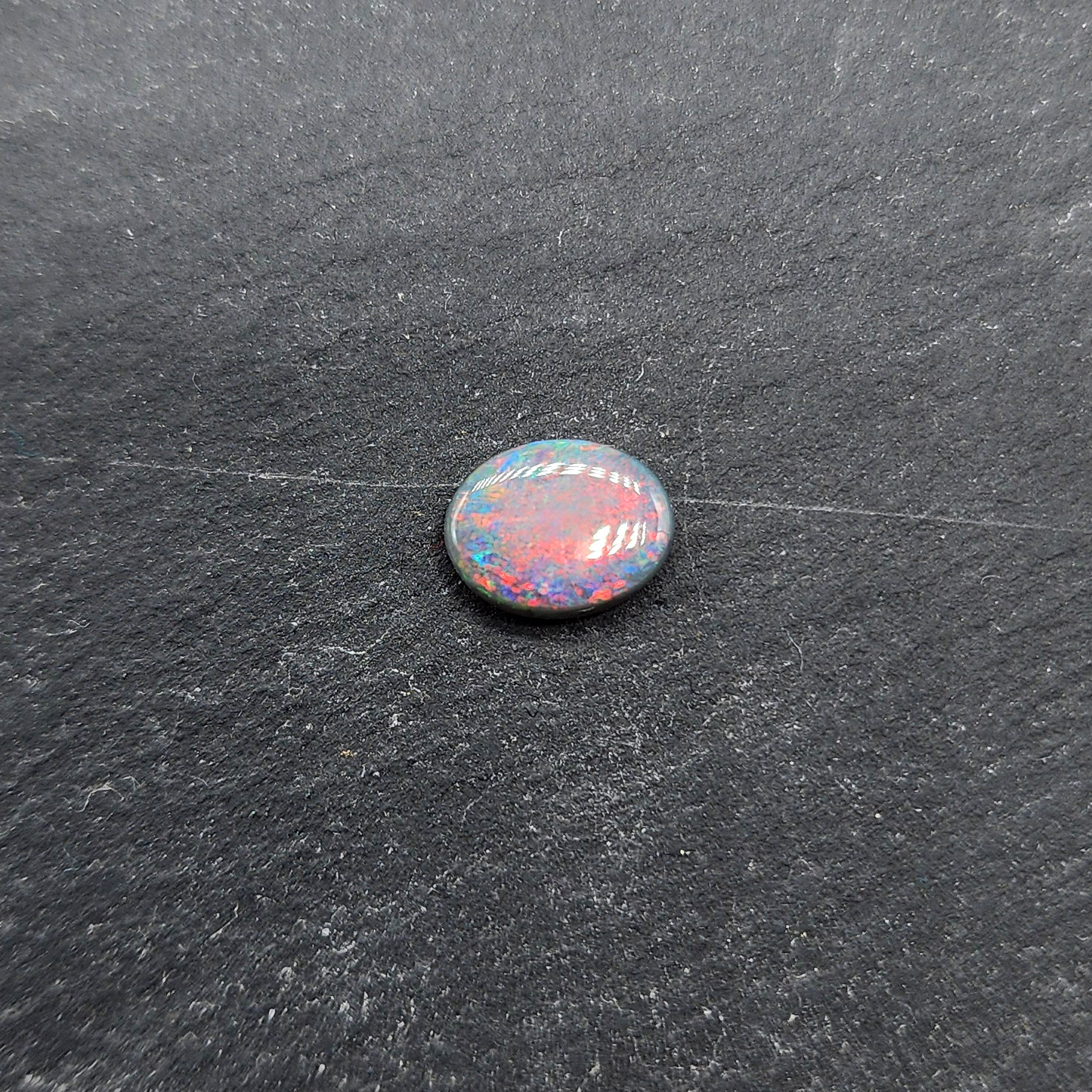 Black opal with bright pink small fire pattern and hints of blue and green