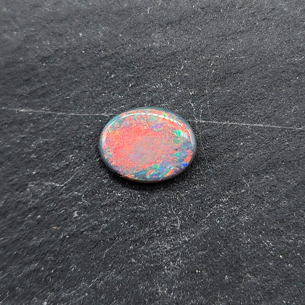 Black opal with bright pink small fire pattern and hints of blue and green