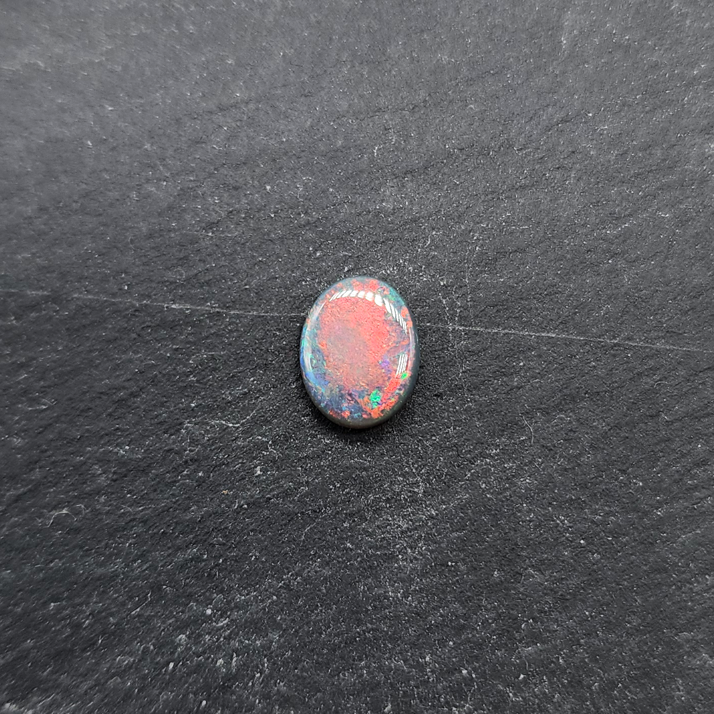 Black opal with bright pink small fire pattern and hints of blue and green