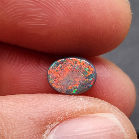 Black opal with bright pink small fire pattern and hints of blue and green