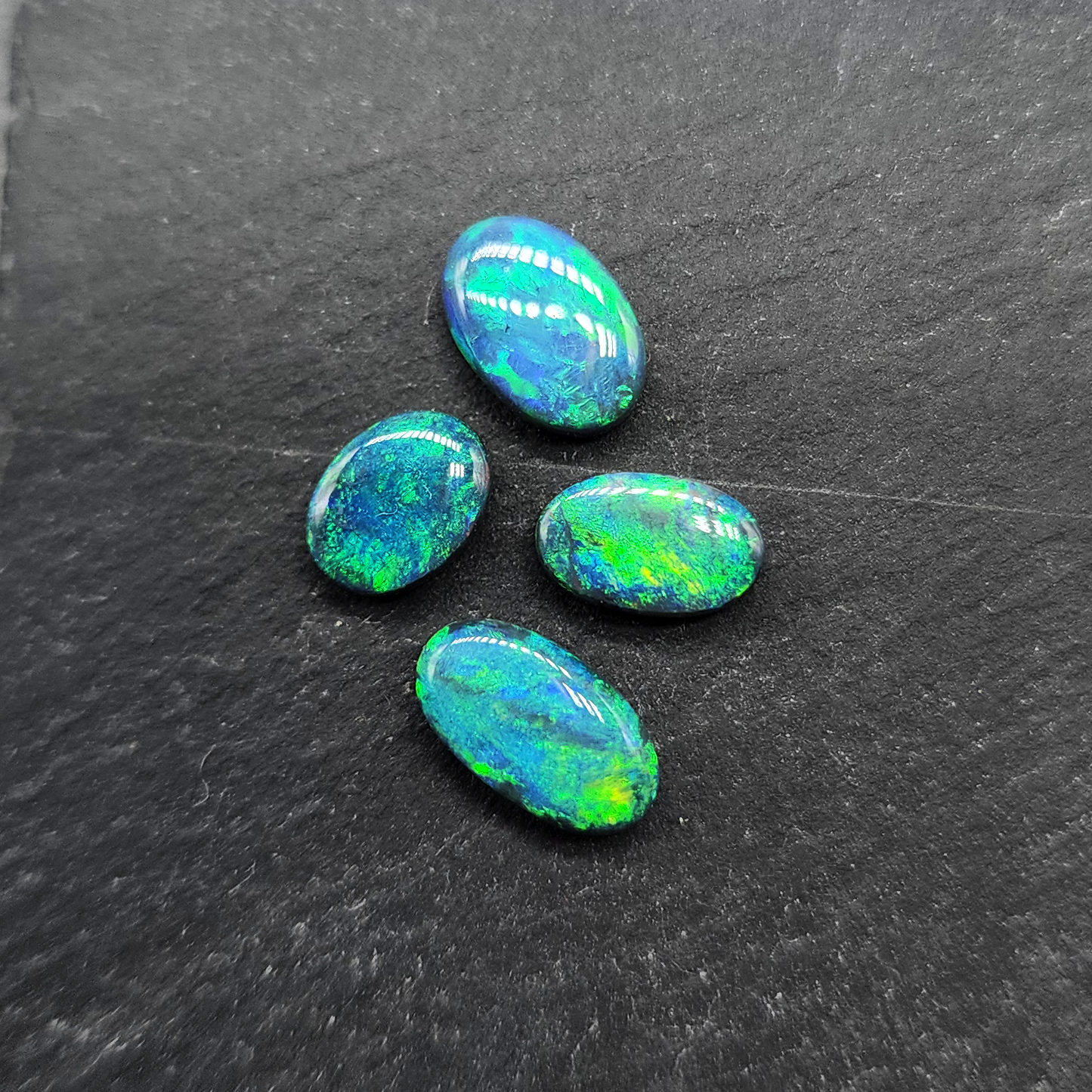 Black Opals with vivid green-blue color play and mossy patterns