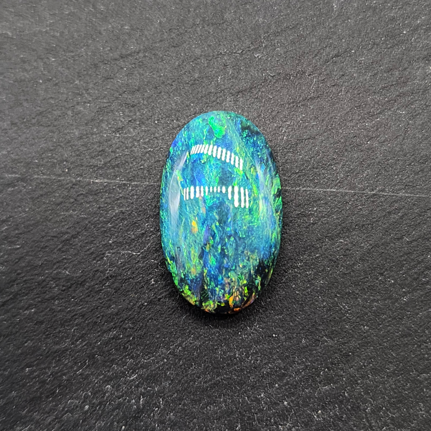 Black opal with a mossy pattern and a green multi color palette.