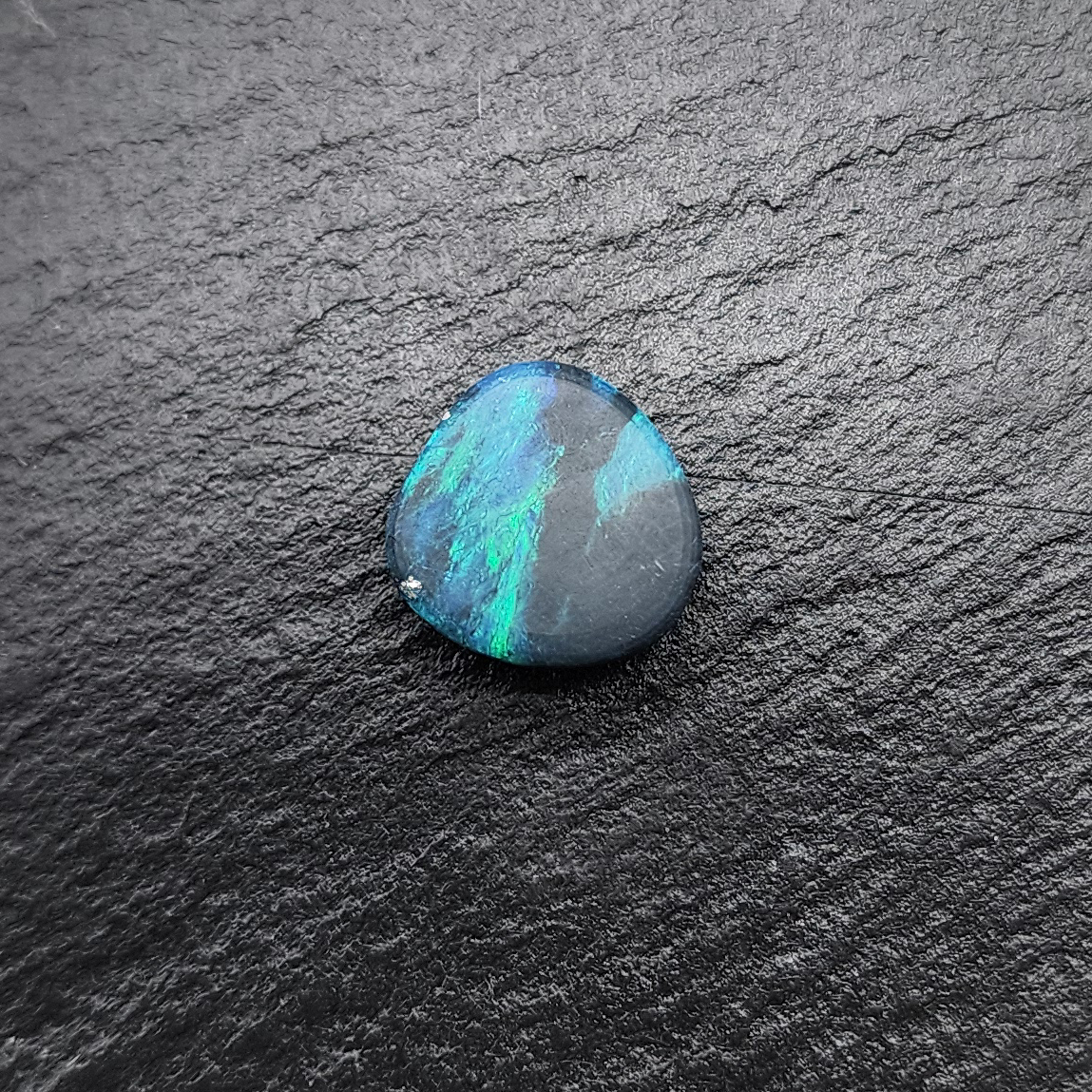 Stunning Black opal with a vivid Green blue color palette and mossy pattern.