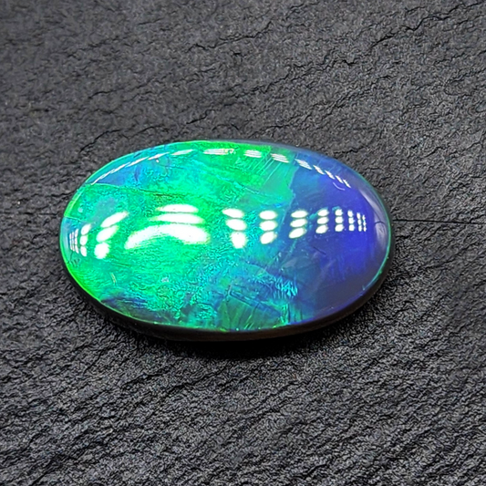 9.1cts Large Black opal with vivid rolling broadflash, transitioning from green to blue