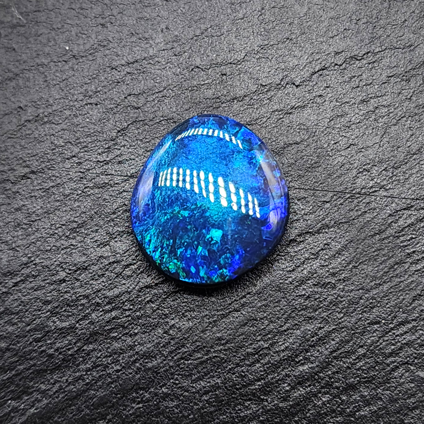 Black opal with vivid blue mossy color play and hints of blue