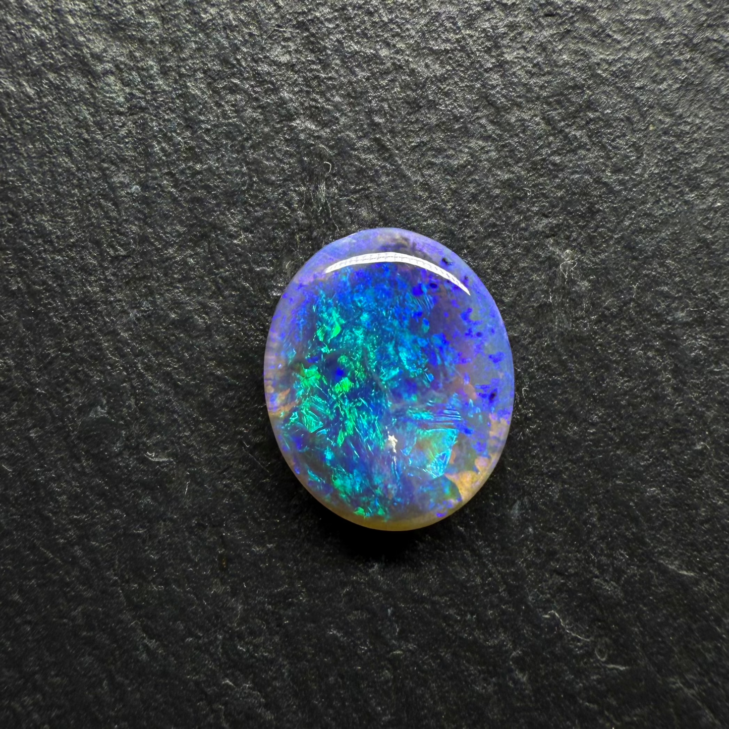 Mysterious Black Crystal Opal With A Central Blue-Green Pattern Fading To Violette At The Edges