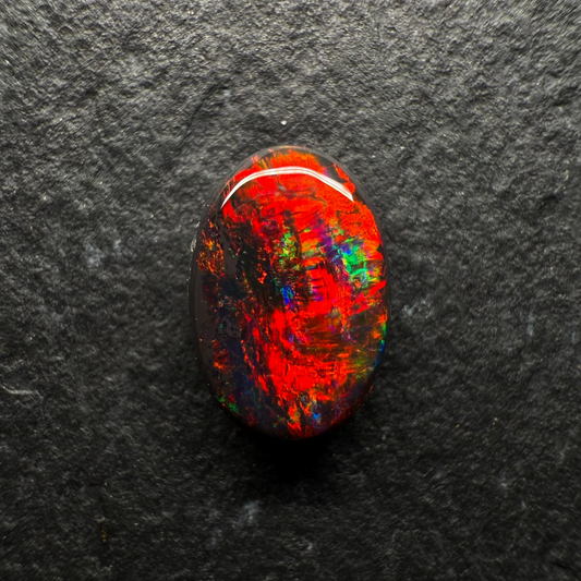 0.7ct World Class Black opal, This stone has a Primarily Pigeons Blood Red Color Palette (The Rarest Color Found In Opal)