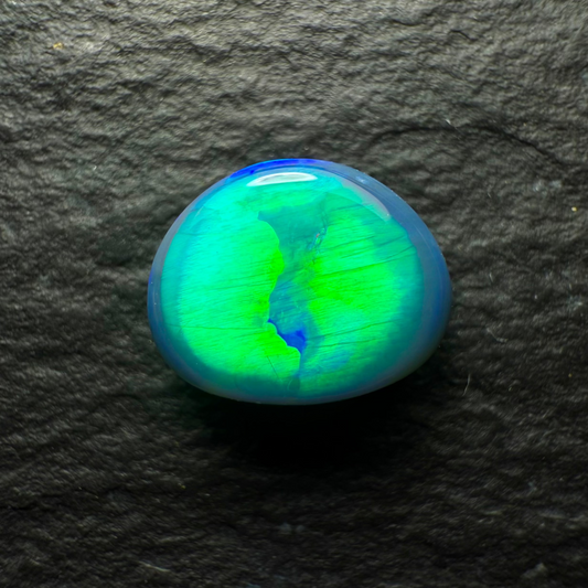 0.74ct Top Gem Black Opal With Brilliant Green Rolling Broadflash Pattern Creating an Eye Like structure In The Center Of The Stone