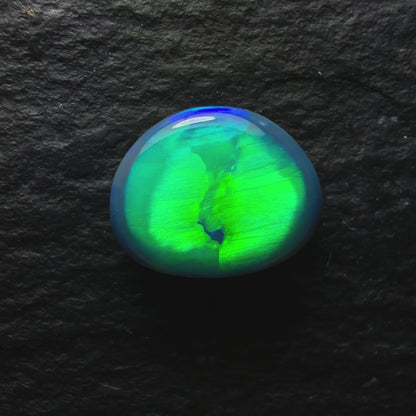 0.74ct Top Gem Black Opal With Brilliant Green Rolling Broadflash Pattern Creating an Eye Like structure In The Center Of The Stone