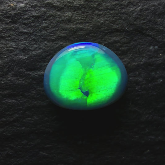 0.74ct Top Gem Black Opal With Brilliant Green Rolling Broadflash Pattern Creating an Eye Like structure In The Center Of The Stone