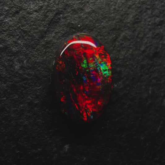 0.7ct World Class Black opal, This stone has a Primarily Pigeons Blood Red Color Palette (The Rarest Color Found In Opal)