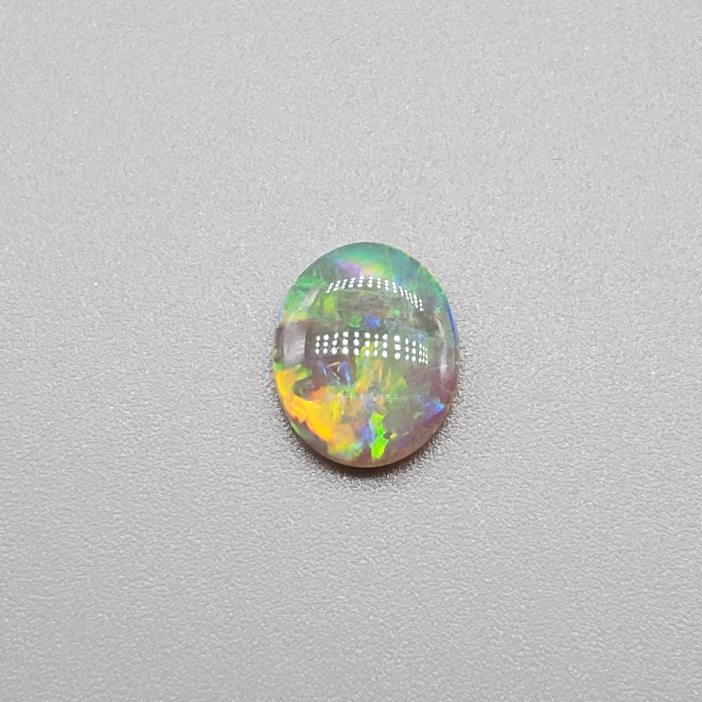 1.0ct Dark opal with Orange Green color play and a well-dispersed pattern