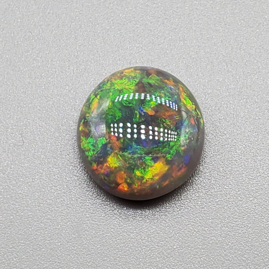 3.3cts Black opal with a rich Green-Orange color pallet and a paint brush stroke pattern.