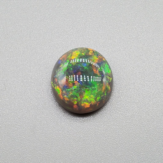 3.3cts Black opal with a rich Green-Orange color pallet and a paint brush stroke pattern.