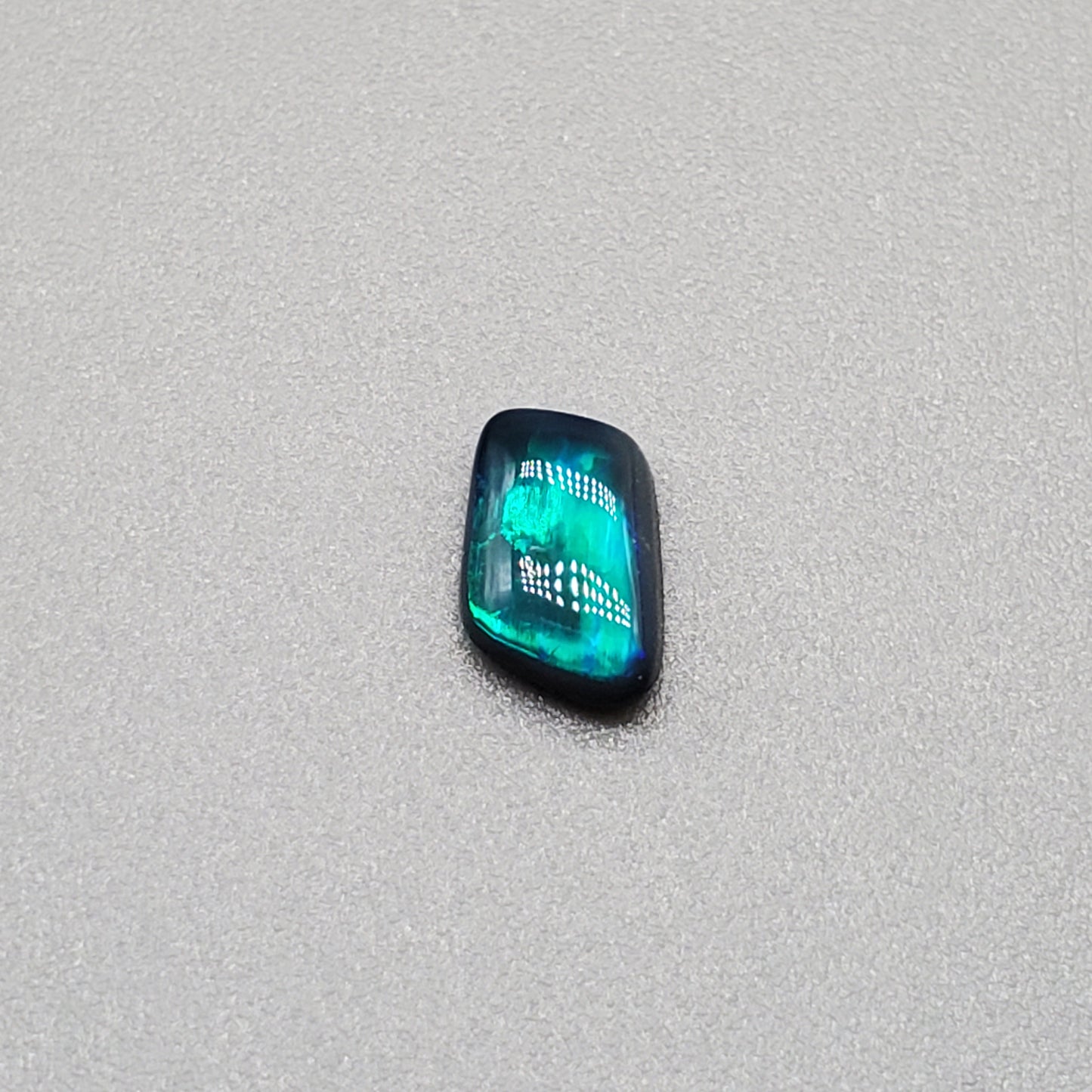 0.50cts Black Opal with iridescent Teal flash and broad rolling flash pattern