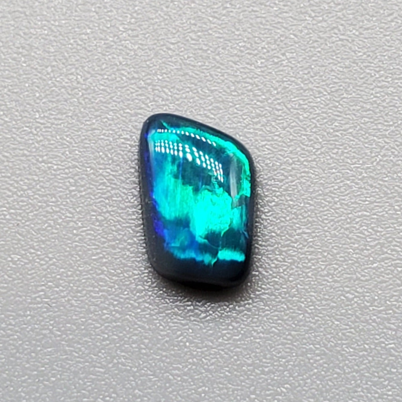 0.50cts Black Opal with iridescent Teal flash and broad rolling flash pattern