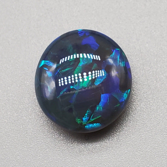 7cts Large Black Opal with well-dispersed, multi-shade Blue color play and an eye catching wispy pattern