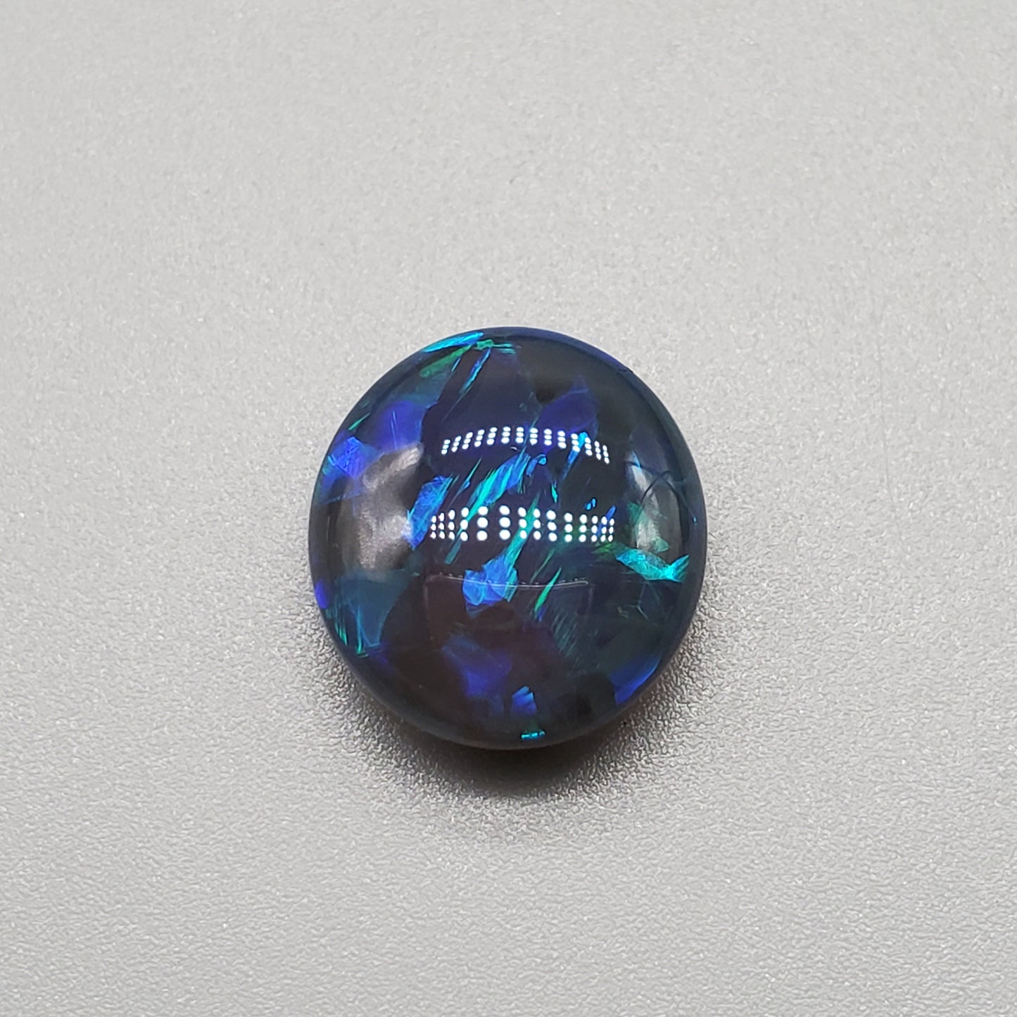 7cts Large Black Opal with well-dispersed, multi-shade Blue color play and an eye catching wispy pattern