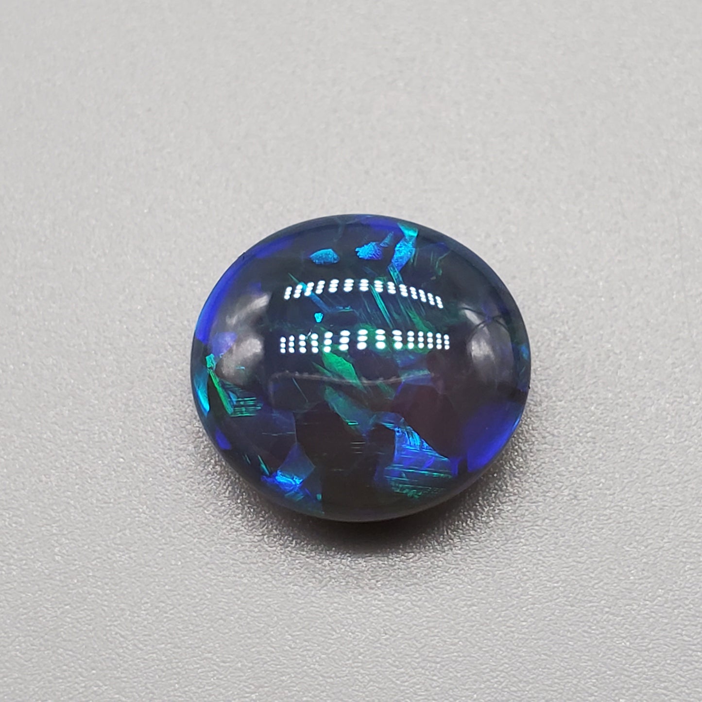 7cts Large Black Opal with well-dispersed, multi-shade Blue color play and an eye catching wispy pattern