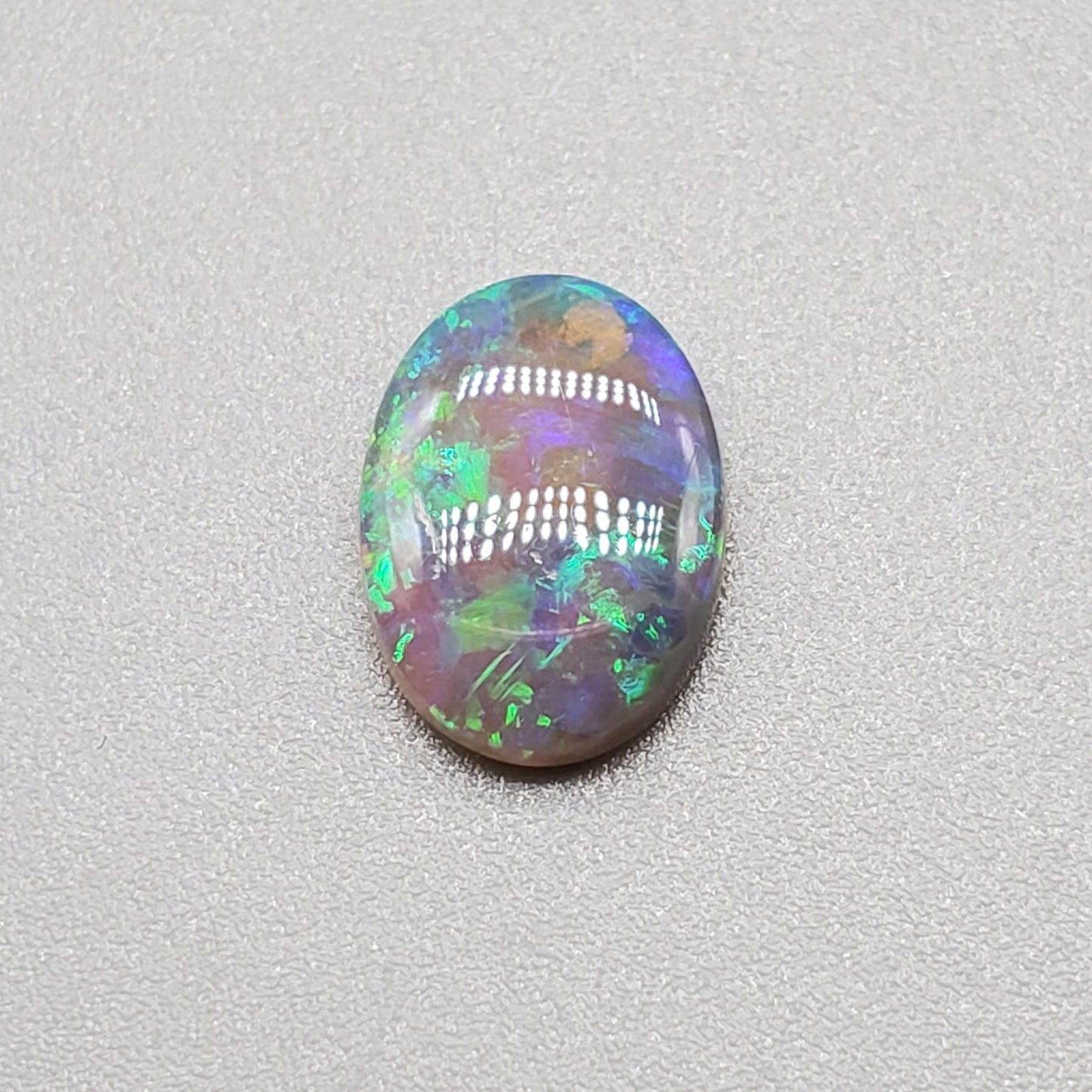 1.3cts  Semi Black Opal with Green-Blue mixed patterns and a translucent dark base