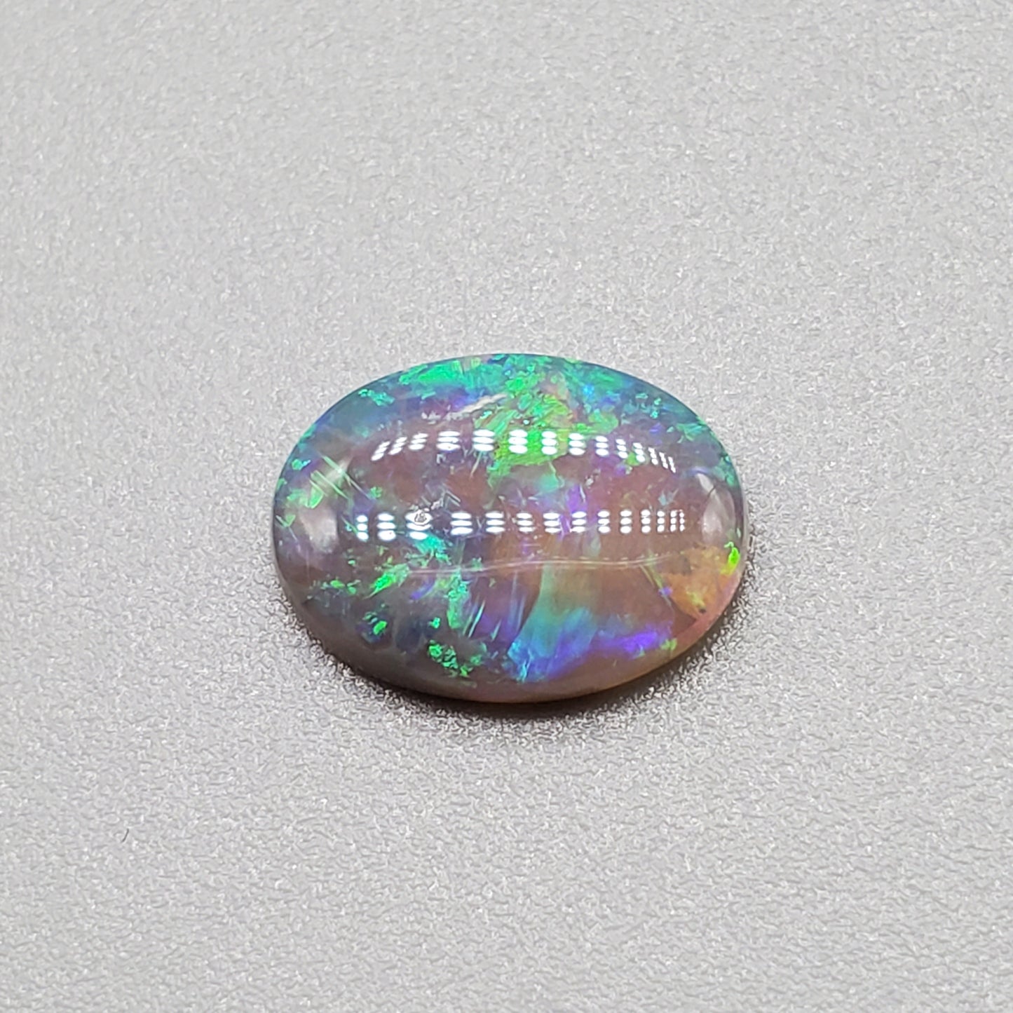 1.3cts  Semi Black Opal with Green-Blue mixed patterns and a translucent dark base