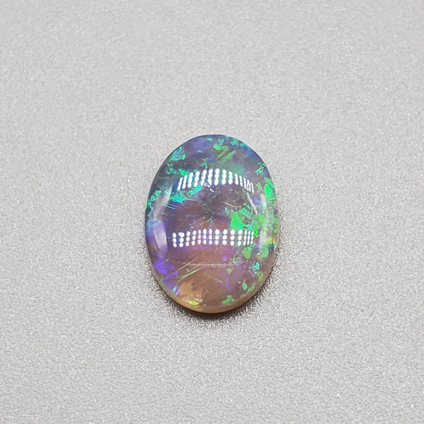 1.3cts  Semi Black Opal with Green-Blue mixed patterns and a translucent dark base