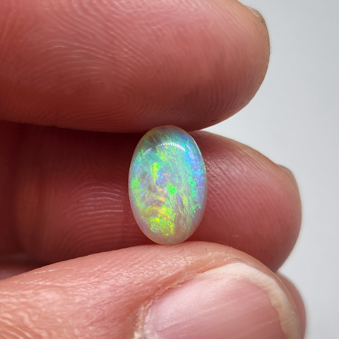 1.7cts Dark opal with a springtime pallet of yellows, greens and light blue