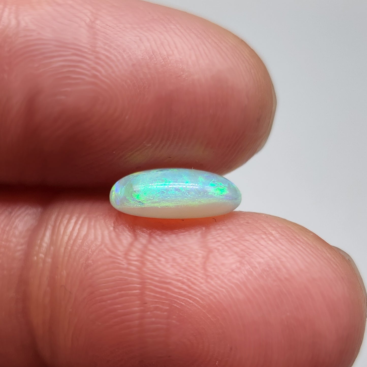 1.7cts Dark opal with a springtime pallet of yellows, greens and light blue