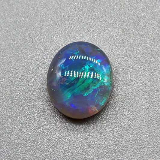 2.5ct Dark opal with a a dark blue base overlane by a minty green chaff pattern