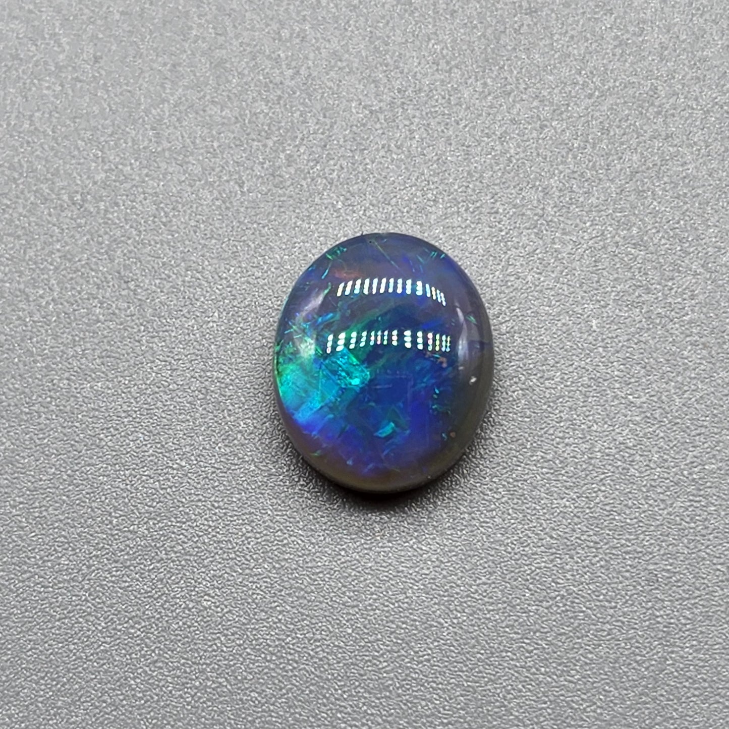 2.5ct Dark opal with a a dark blue base overlane by a minty green chaff pattern