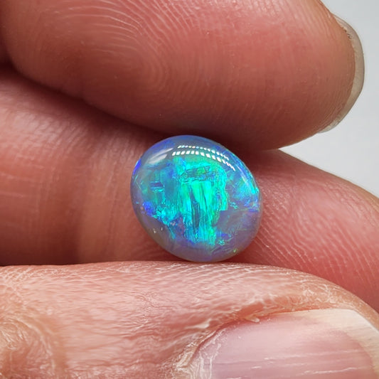 2.5ct Dark opal with a a dark blue base overlane by a minty green chaff pattern