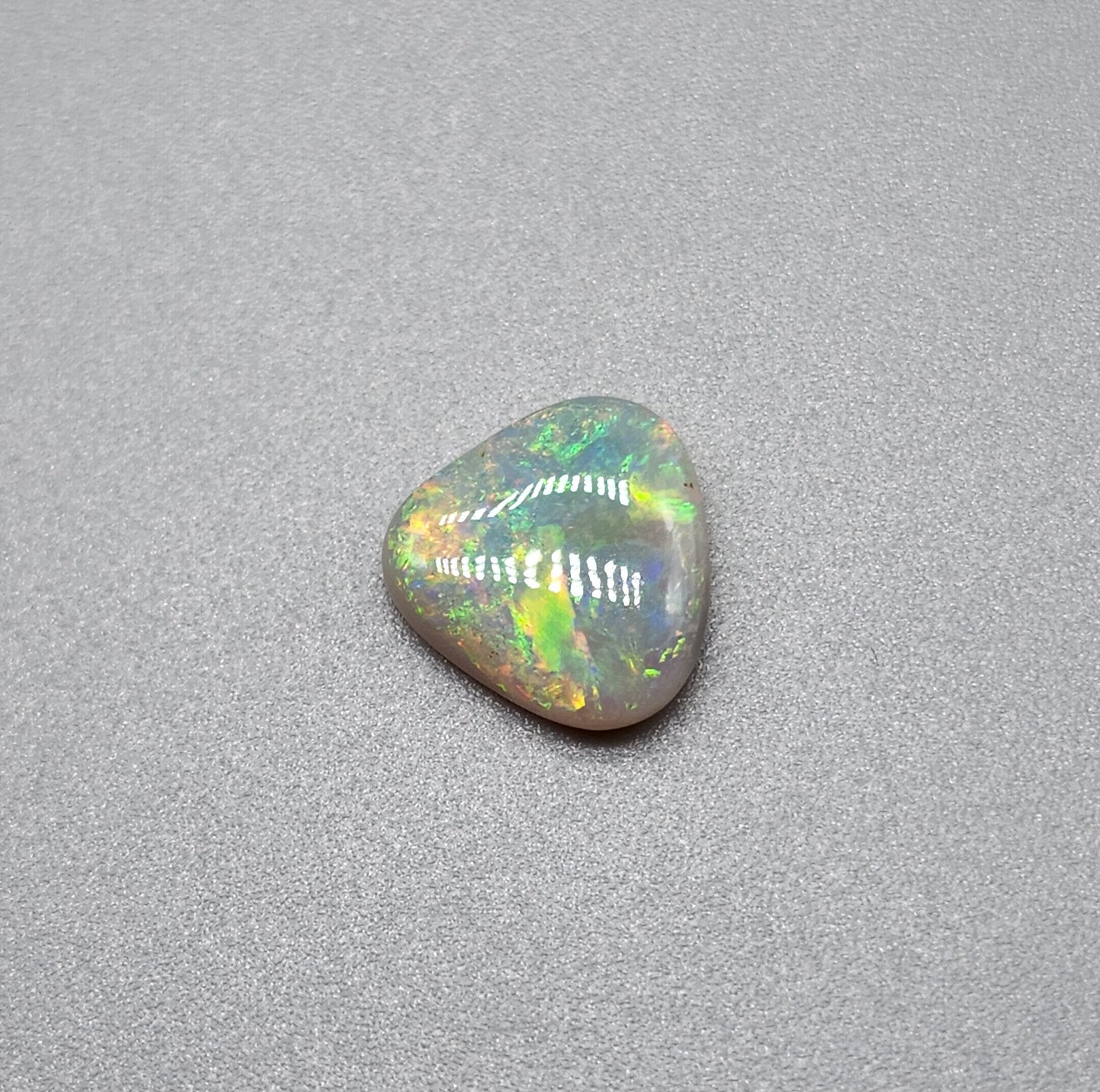 1.5cts  Dark opal with yellow, green, orange color play and mixed pattern