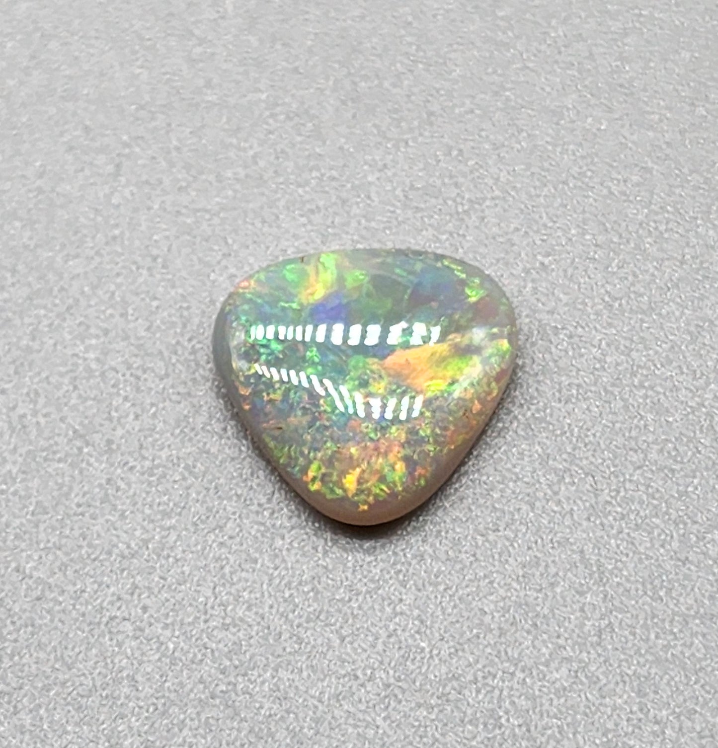 1.5cts  Dark opal with yellow, green, orange color play and mixed pattern