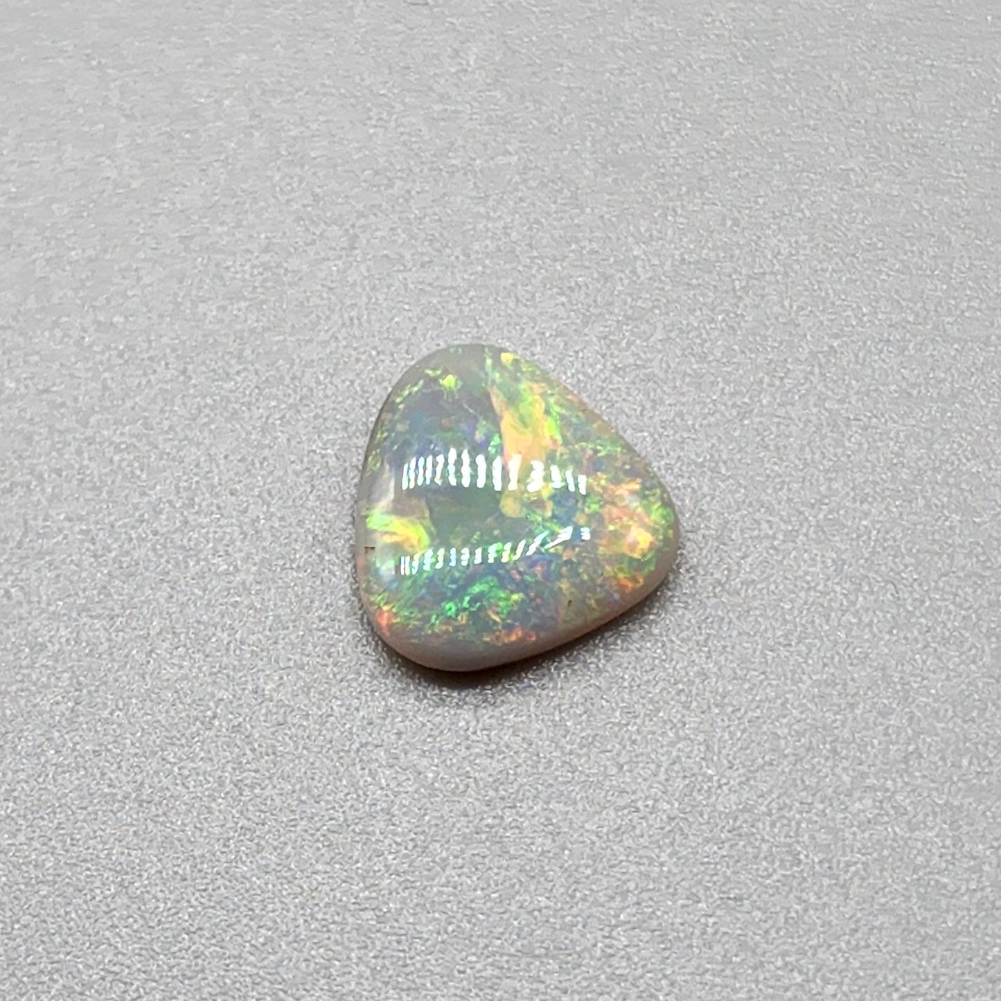 1.5cts  Dark opal with yellow, green, orange color play and mixed pattern