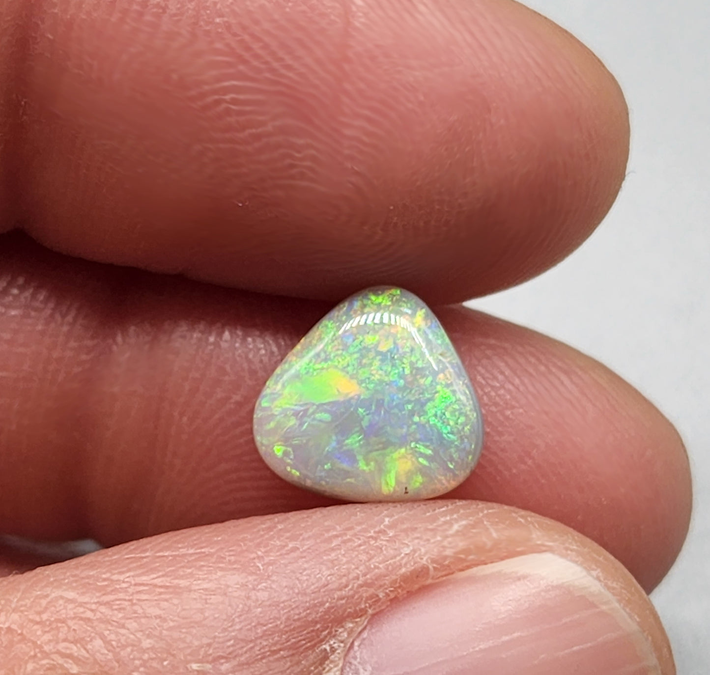 1.5cts  Dark opal with yellow, green, orange color play and mixed pattern